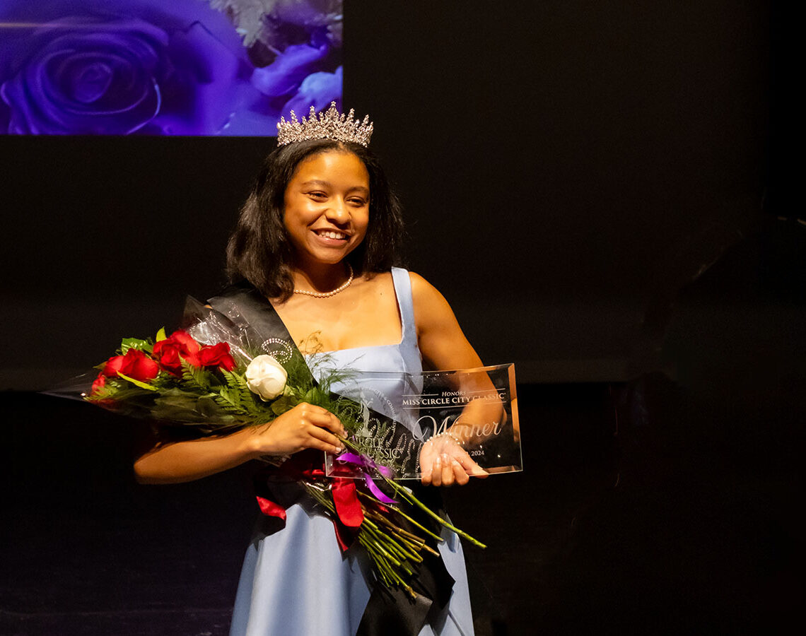 girl holding trophy and flowers